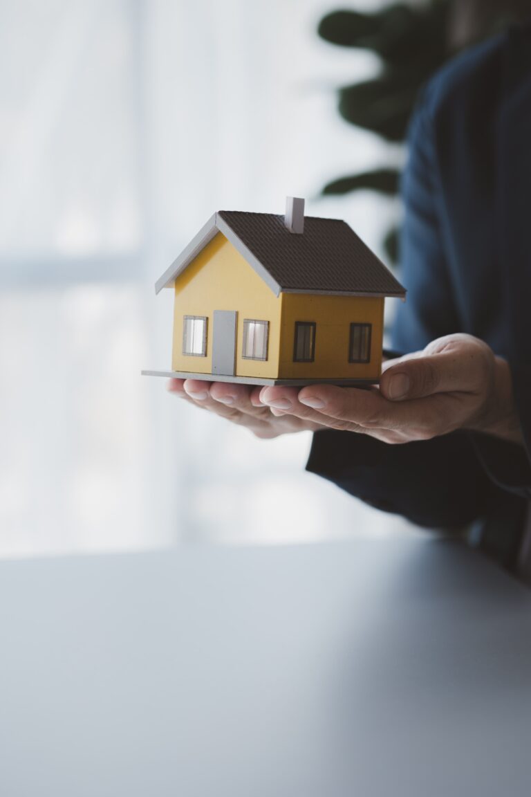 Poly Foam Chemical Grouting Services New York - A Man Holding a Small House with Both Hands Over a Table