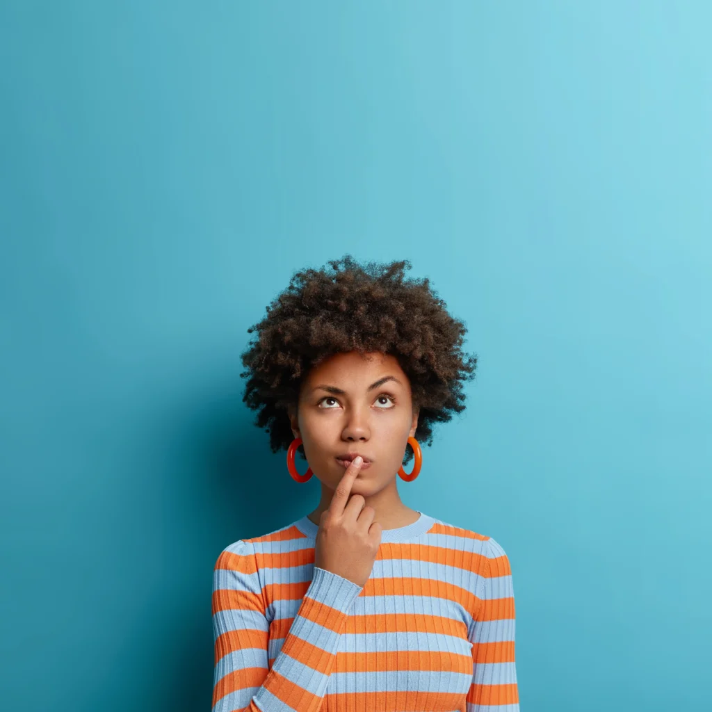 What Are Push Piers and How Do They Work? - A Woman Standing in Front of a Light Blue Background with Her Finger Over Her Mouth Looking Confused