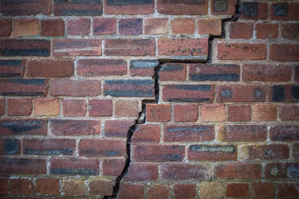 Push Piers - A Red Brick Wall with Stair-Step Cracks from Foundation Settlement