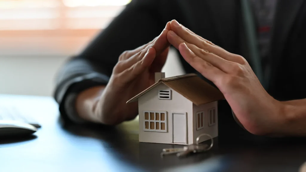 Benefits of Using Retaining Walls for Flood Prevention - A Small House Model and a Man Cupping His Hands Over It