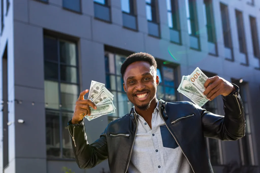 Federal Grants for Historic Buildings - A Man Outside a Building Holding Two Handfuls of Cash