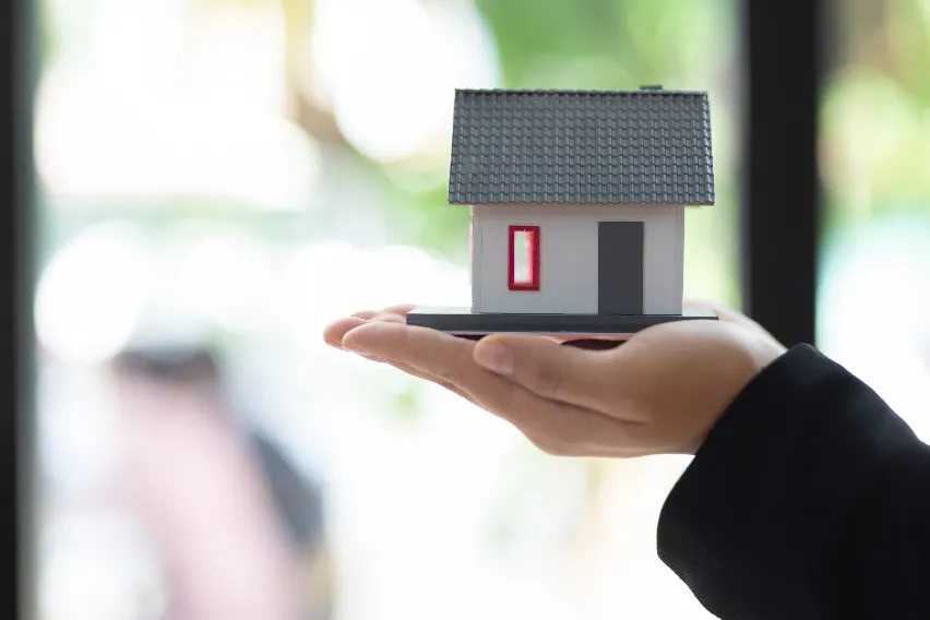 Helical Pier Installation for Manhattan Properties - A Man Holding a Small House Model in His Hand