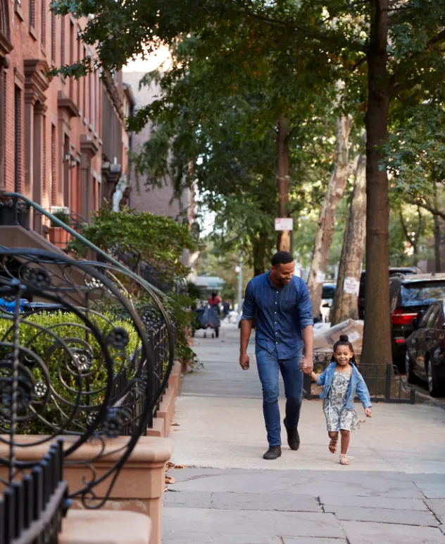 Brownstone Contractors in Brooklyn - A Man Walking with His Daughter in Front of a Historic Brooklyn Brownstone in Manhattan