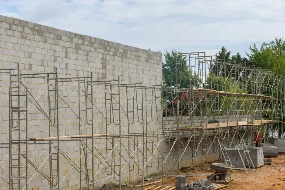 Concrete Block Retaining Wall Guide - A Concrete Block Retaining Wall Being Constructed Around a the Site of a New Commercial Shopping Center