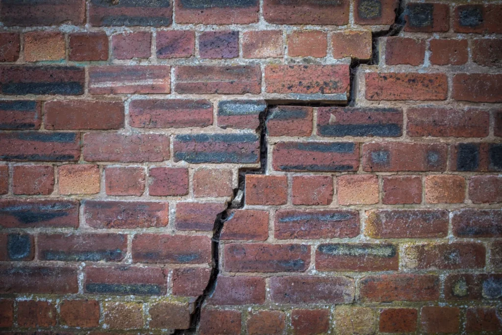 How Can Water Damage Concrete Foundation - A Foundation Crack in a Brick Wall with a Stair Step Pattern